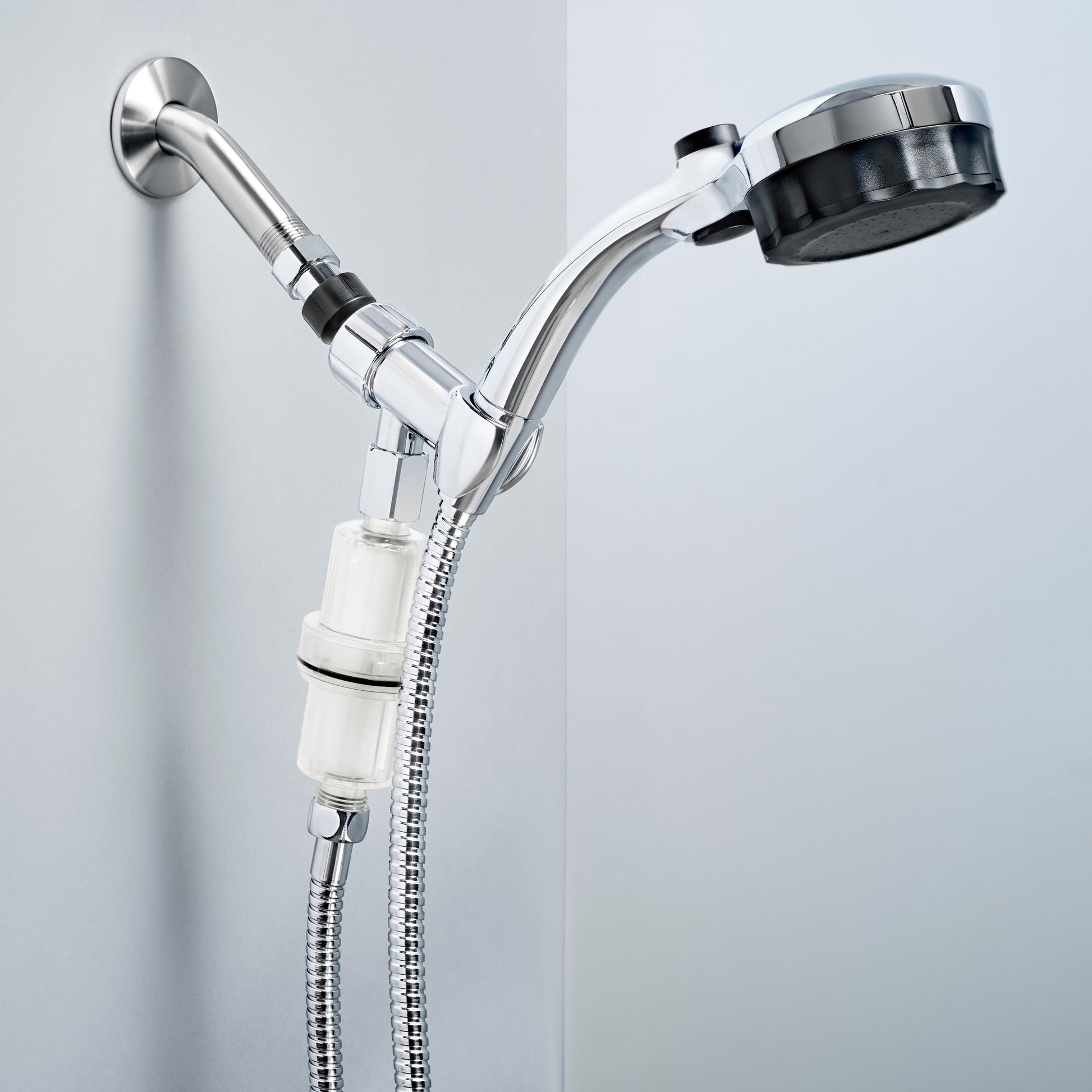 A silver Microbubble Showerhead attached to a wall with a clear filter bottle mounted below, connected to a flexible shower hose.