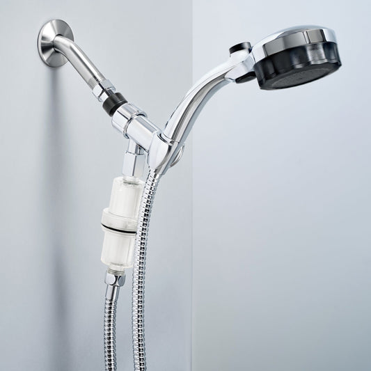 A silver Microbubble Showerhead attached to a wall with a clear filter bottle mounted below, connected to a flexible shower hose.